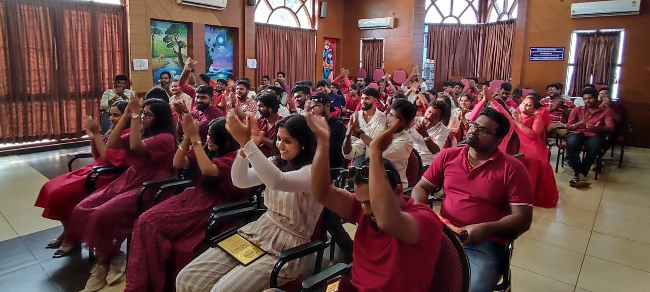 A diverse group of corporate employees standing and applauding in a large auditorium during an awards ceremony.